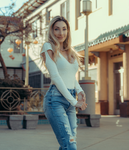 Woman in jeans and a white shirt standing outside